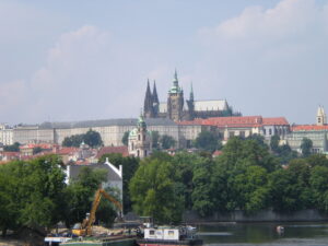 Prague Castle towering over the trees across the Vltava River.