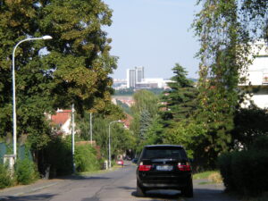 A neighborhood at the top of a hill with an SUV parked on the street.
